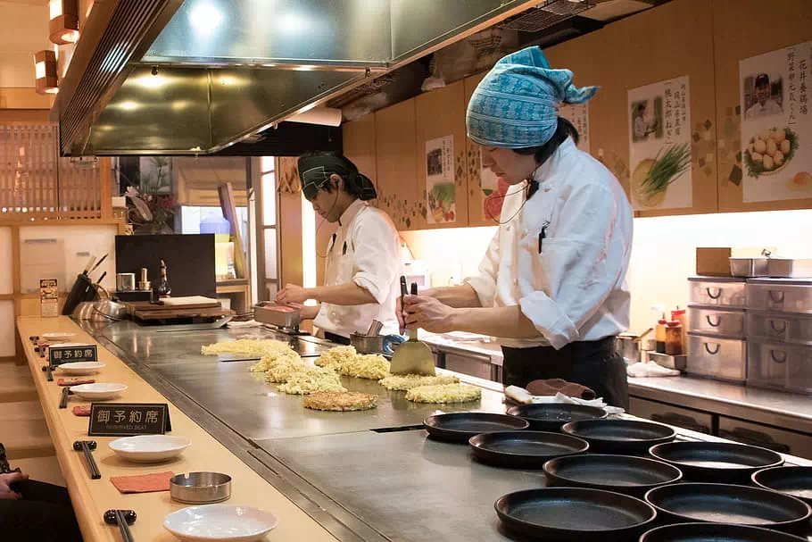 préparation du plat d'okonomiyaki sur plancha
